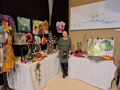 Xmas-Open Verkaufsstisch mit gefilzten Produkten und Kunstwerken an der Wand